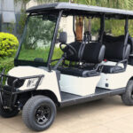 Three quarter view of the 4+2, passenger, electric, white Fusion electric cart parked near shrubbery and trees.