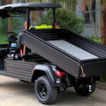 Black, two-seater, long bed Fusion commercial utility vehicle showing off the rear dumping capabilities in action.